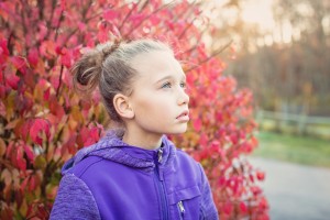 young girl in front of tree